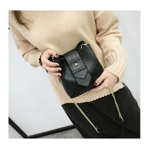 Close-up of black PU leather bucket bag with gold metal buckle and elegant chain strap