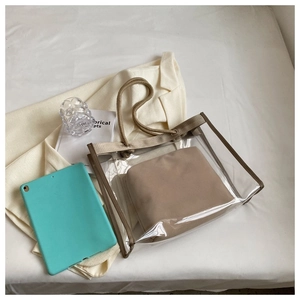 Close-up of clear PVC tote with thick rope handles and private khaki inner pouch