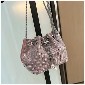 Détail du sac seau rose à strass avec fermeture à cordon et pompons en perles