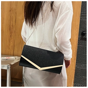 Detail of black glitter evening clutch featuring golden V-shaped buckle and chain strap