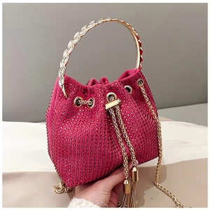 Détail du sac seau strass rose avec poignée feuille dorée et cordon à pompons métalliques