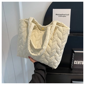 Detailansicht der beigefarbenen Stepptasche mit Wellennaht und Magnetverschluss