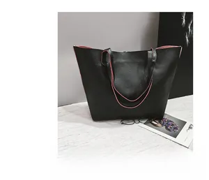 Detail view of the black lychee pattern leather tote bag with vibrant pink contrast lining