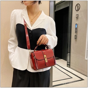 Dettaglio borsa vintage in pelle cerata rossa con fibbia in metallo indossata da una modella
