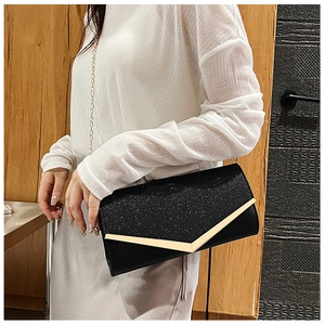 Detail of black sequin clutch bag with gold V-shape metal trim and chain strap