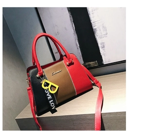 Détail du sac à main tricolore en cuir avec texture litchi et logo doré élégant