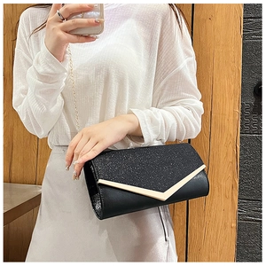 Detail of black envelope clutch with gold V-trim, glitter panel and chain strap