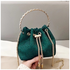 Détail du sac seau en strass vert avec poignées dorées et bandoulière chaîne