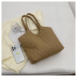 Draufsicht auf einen khakifarbenen Stepp-Tote-Bag mit Blattmuster auf weißem Stoff