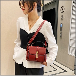 Borsa a mano alla moda in pelle cerata rosso scuro con fibbia dorata sul modello