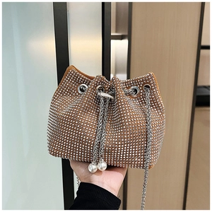 Détail d'un sac seau marron avec strass argentés, bandoulière chaîne et glands en perles