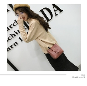 Close-up of stylish reddish brown crossbody phone bag with gold chain strap on model