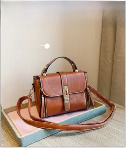 Dettaglio della borsa vintage in pelle cerata marrone con chiusura girevole dorata