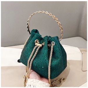 Gros plan du sac seau vert foncé en strass avec poignée dorée et chaîne en métal
