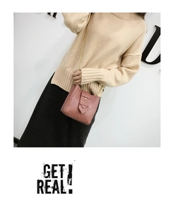 Detail view of pink crossbody phone bag with gold chain strap and elegant leather buckle