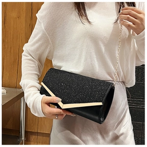 Close-up of black sequin evening clutch bag with gold V-shaped metal trim and chain