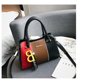 Détail du sac à main tricolore en cuir grainé avec pendentif B métallique élégant