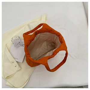 Draufsicht der orangefarbenen gesteppten Tasche mit großem Innenraum und Magnetverschluss