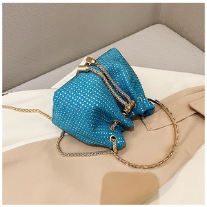Détail du sac seau en strass bleu roi avec poignée anneau dorée et sa chaîne