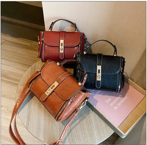 Dettaglio di borse retrò in pelle cerata nei colori rosso, nero e marrone con fibbie in metallo