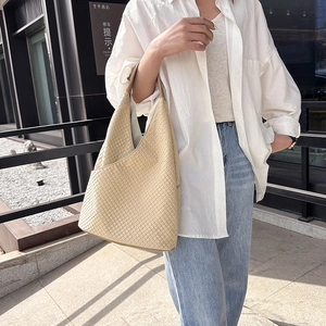 Minimalistische beige Schultertasche mit Waffelstruktur und elegantem, gebogenem Design