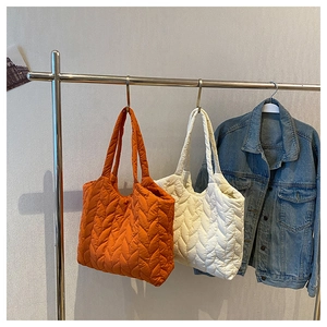 Detail der gesteppten Tragetasche mit Wellenmuster in den Farben Orange und Cremeweiß