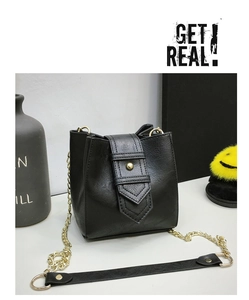 Detail of black pebbled bucket bag with gold studs and a chain shoulder strap