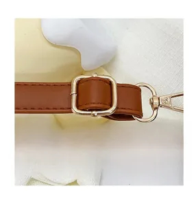 Detail of adjustable brown leather shoulder strap with gold buckle and swivel hook