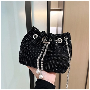 Détail du sac seau en strass noirs avec chaîne argentée et pompons de perles blanches