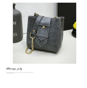 Detail of grey vintage washed PU leather bucket bag with gold chain and round buckle