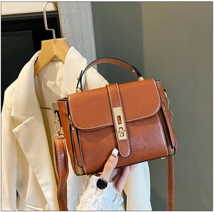Dettaglio borsa a mano in pelle cerata marrone vintage con chiusura dorata