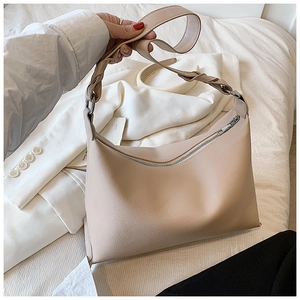 Dettaglio borsa a tracolla beige texture litchi con manico intrecciato e zip argento