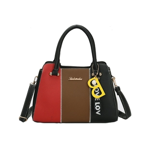 Sac à main tricolore chic avec texture litchi et logo doré sur fond blanc