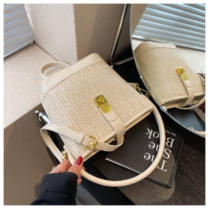 Detail of bohemian straw tote featuring herringbone weave texture and gold metal turn-lock