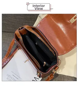 Vista interna della borsa in pelle marrone con due tasche principali e scomparto con zip