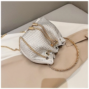 Détail du sac seau de soirée étincelant avec strass, chaîne dorée et poignée ronde en métal