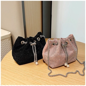 Détail d'un sac seau en strass avec cordon de perles et bandoulière en chaîne argentée