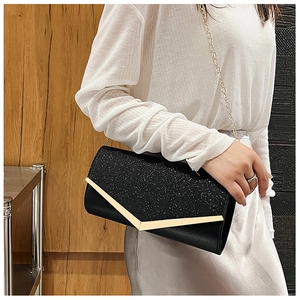 Detail of elegant black clutch bag featuring starry sequins and golden V-shaped metal trim