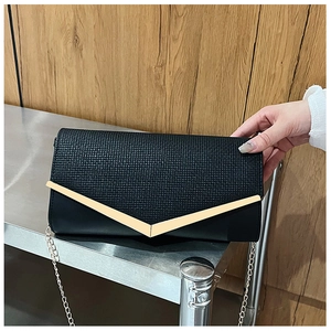 Detail of black envelope clutch featuring square embossed texture and V-shaped gold trim
