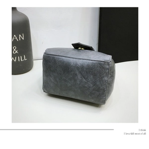 Detail showing the gray textured leather side view with precise double stitching on the bag