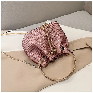 Détail du sac seau en strass rose avec poignée en anneau doré et bandoulière chaîne