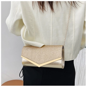 Detail of glitter envelope clutch bag with gold V-shape trim and fine chain strap