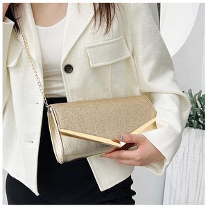 Detail view of luxury golden sequin clutch bag with metallic V-shaped trim and long chain