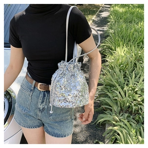 Détail du sac seau à paillettes argentées avec fermeture à cordon et fine bandoulière
