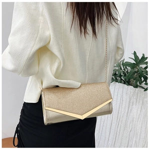 Close-up of a gold glitter envelope clutch bag with metal V-buckle and chain strap