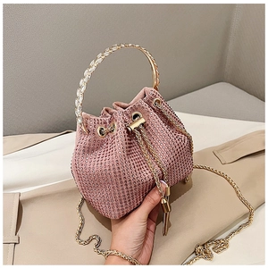 Détail du sac seau à strass rose avec poignée dorée et texture cristal scintillante