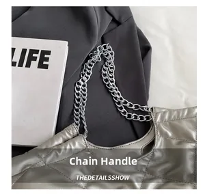 Detail view of the silver metallic quilted tote bag with silver chain handle and stitching
