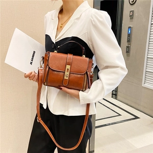 Borsa tote vintage in pelle marrone con manico e tracolla indossata da una modella