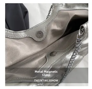 Detailed macro view of the silver metallic bag showing the magnetic snap closure