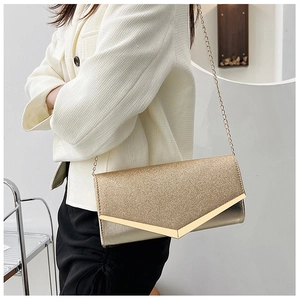 Detail of a gold glitter evening clutch bag with V-shaped metal trim and fine chain strap